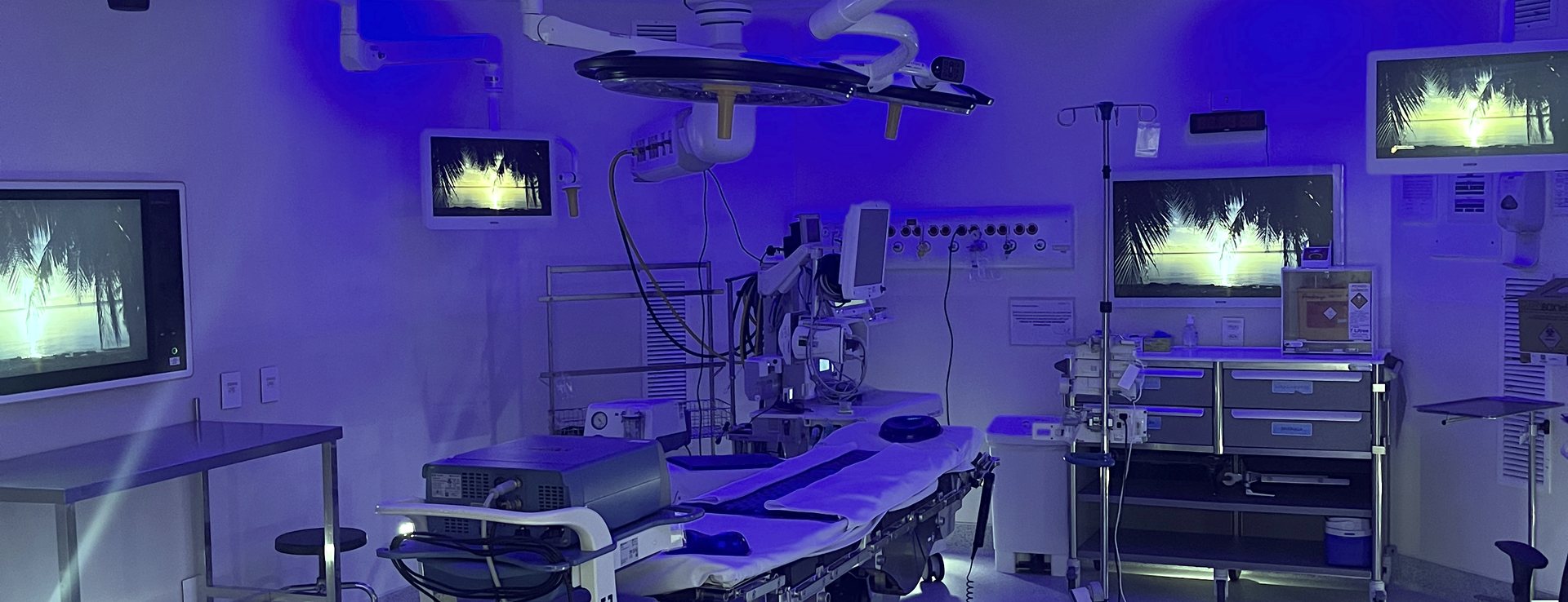 Sala de cirurgia montada para videotoracoscopia, com mesa cirúrgica, focos de teto e monitores de vídeo.